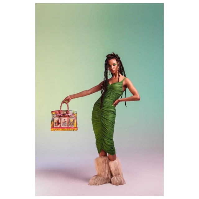Full shot of a woman in a green dress posing with a pink and clear purse against a gradient background, fashion and beauty.