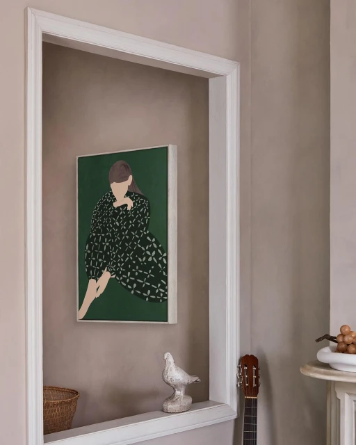 Illustration of a woman in green dress hanging on a wall above a decorative shelf with a white ceramic bird and small guitar. 