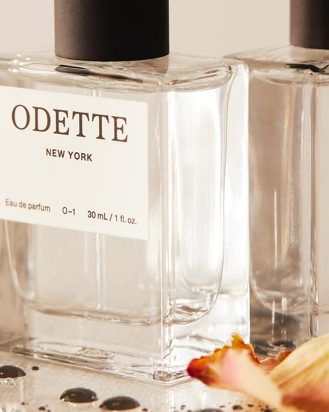 Close-up product photography of Odette New York perfume bottles with clear glass and a white label, shot by Kate Jordan