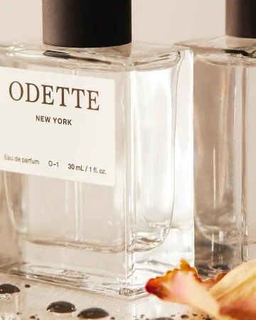 Close-up product photography of Odette New York perfume bottles with clear glass and a white label, shot by Kate Jordan