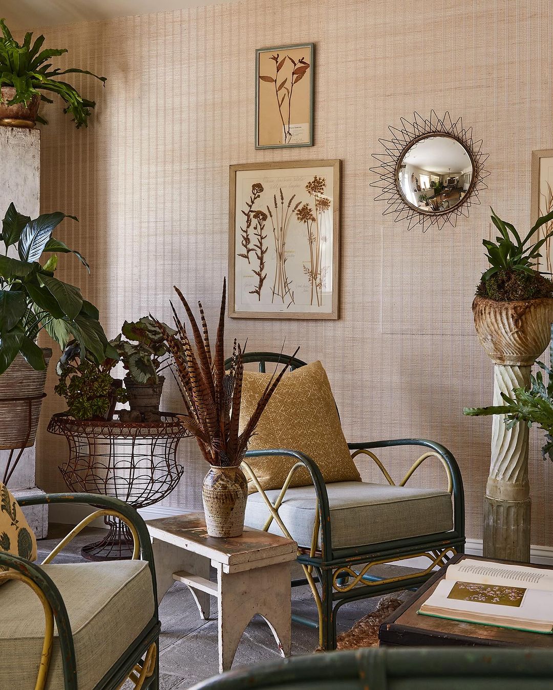 Cozy indoor scene with rattan chairs, lush potted plants, botanical wall art, soft lighting, and neutral color palette creating a tranquil space.