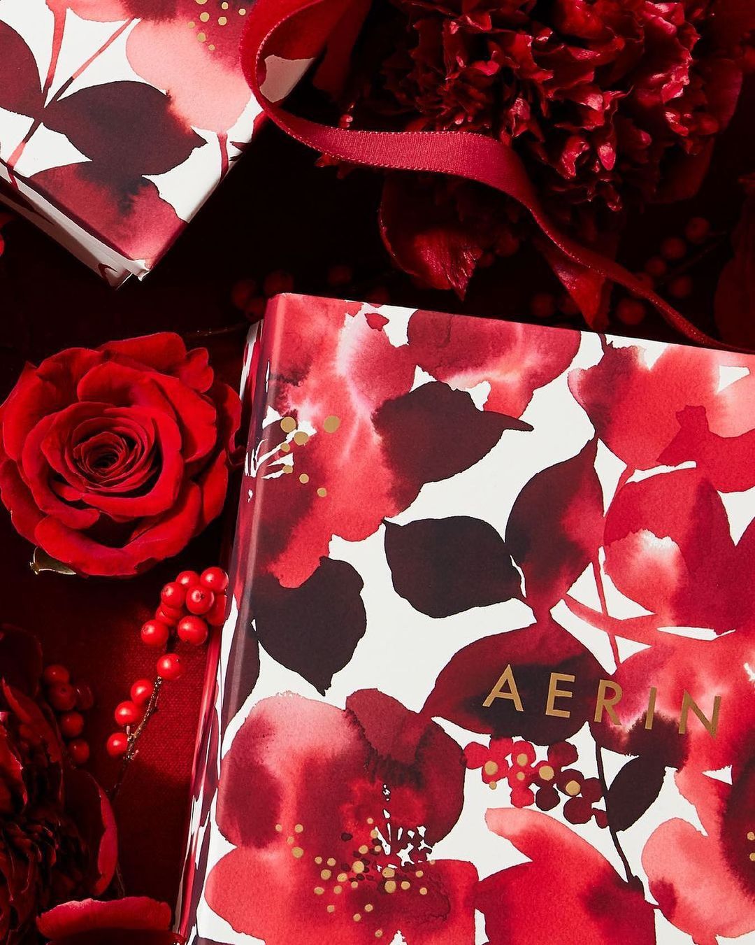 Floral gift boxes and red roses create a vibrant display. Festive arrangement with a close-up view and a luxurious feel.