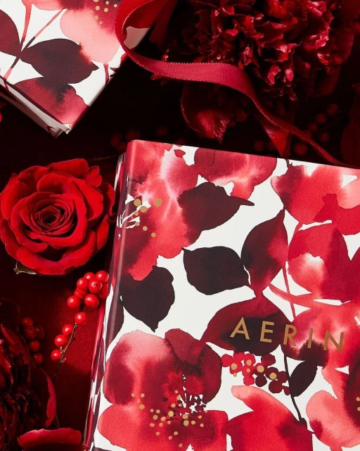 Floral gift boxes and red roses create a vibrant display. Festive arrangement with a close-up view and a luxurious feel.