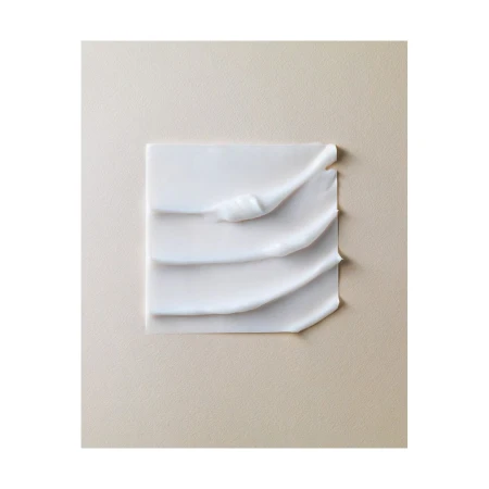 Close-up studio shot of white cream texture on a neutral beige surface. Beauty product concept with minimalist composition.