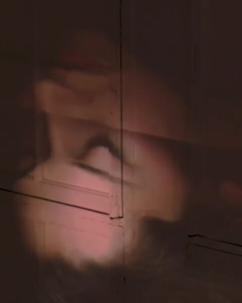 Abstract image featuring a partially visible person with warm color palette of soft browns and hints of pink.
