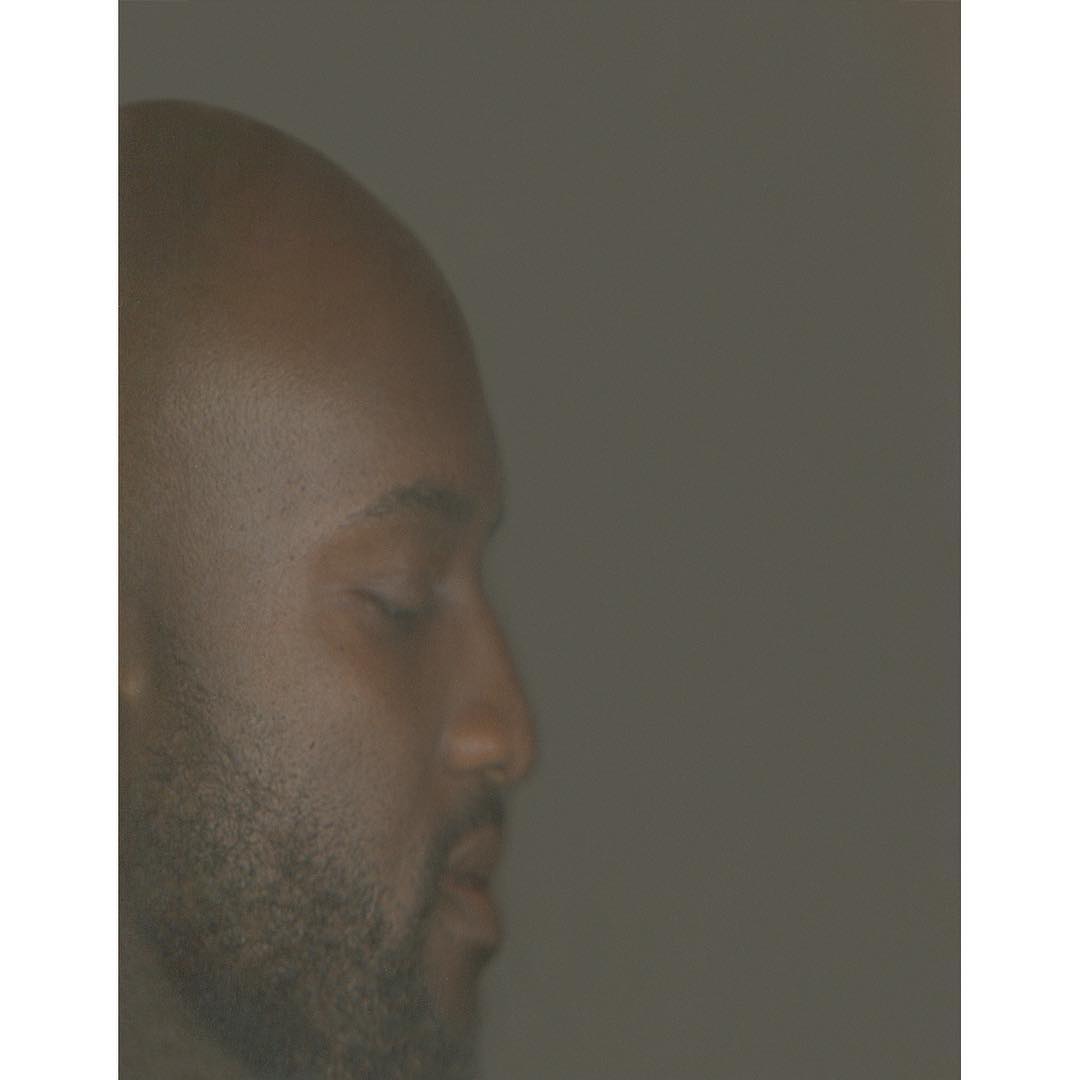 Close-up of an African American male with closed eyes, showcasing his facial features in soft, diffused lighting against a muted background.