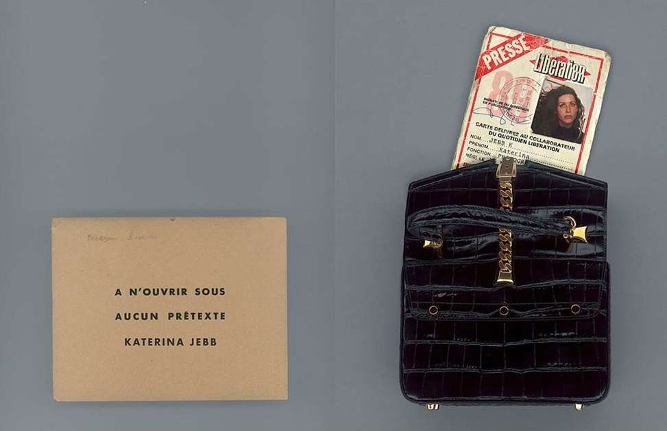 Still life of an opened black handbag with a Presse Liberation card, and a tan card with text that reads: A N'OUVRIR SOUS AUCUN PRÉTEXTE.