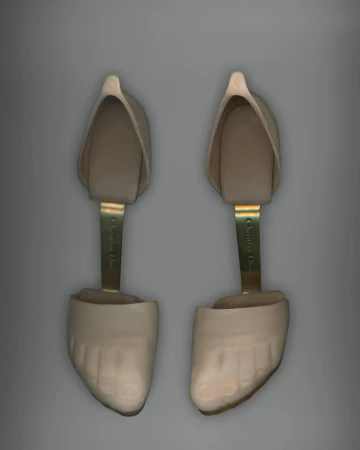 Pair of Christian Dior shoe stretchers on a grey background, presented in a studio product shot with bright, even lighting.