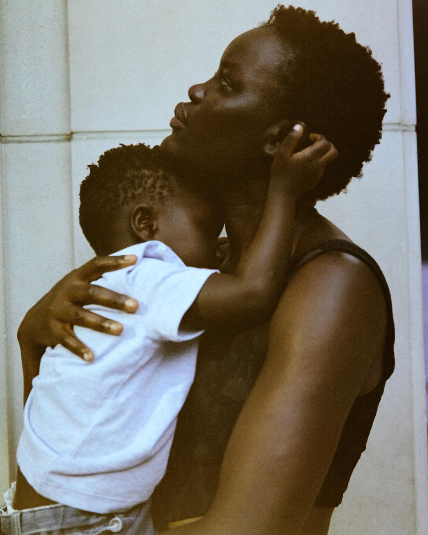 Portrait of an African-American mother lovingly holding her young child, with soft, natural lighting highlighting their skin tones and affection.