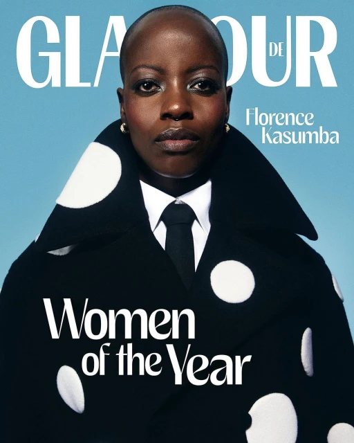 Glamour magazine cover featuring Florence Kasumba in a black and white polka-dot jacket, tie, and a blue background. Text reads 'Women of the Year'.
