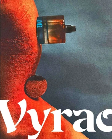 Close-up profile of a person with textured orange skin, a perfume bottle on their head, and a circular disc on their neck against a dark background