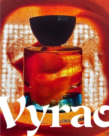 Close-up product shot of a translucent amber perfume bottle with a dark cap against an abstract fiery red background