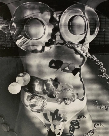 Monochrome torso with glass objects, jewelry, and geometric shapes creating an abstract, surreal, and artistic nude female figure.
