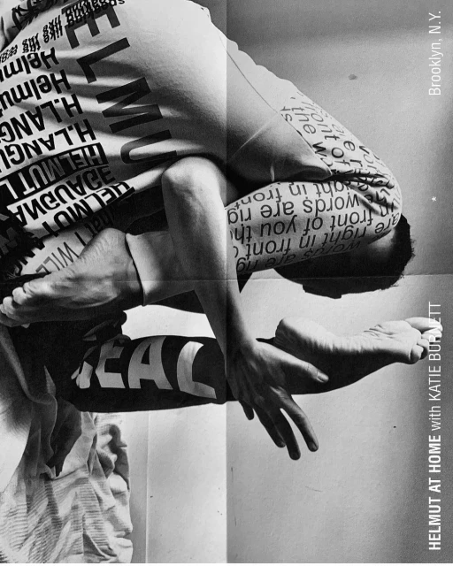 Black and white studio shot of a human figure in a twisting yoga pose wearing text-covered pants and a t-shirt with text and graphic design.