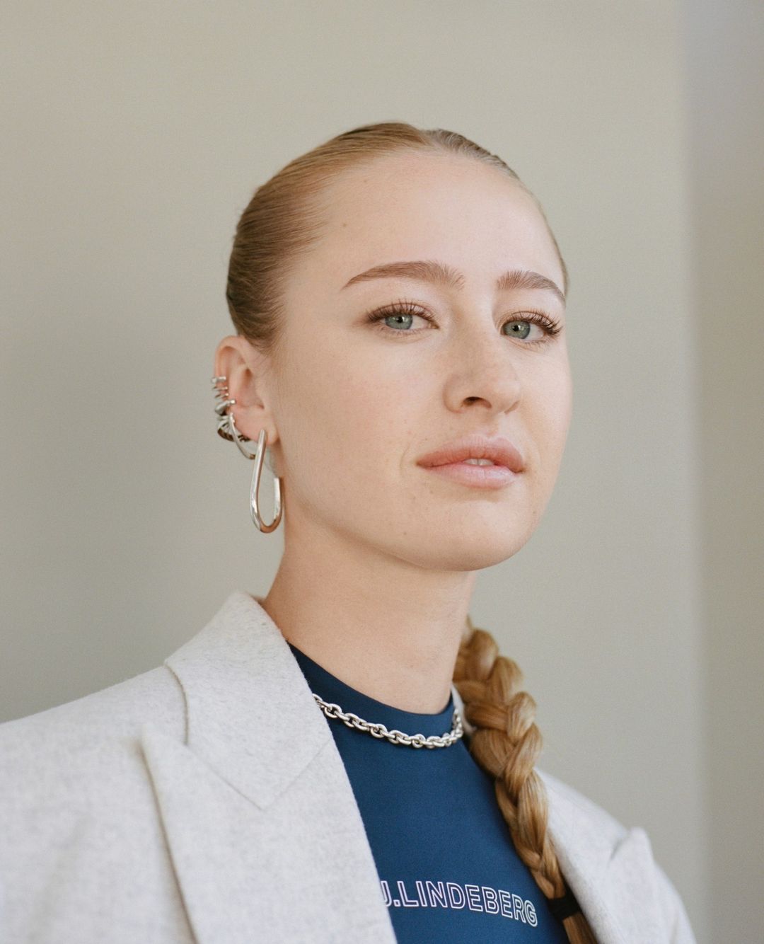 Portrait of a blonde woman wearing a light blazer and silver earrings by Katie Mccurdy