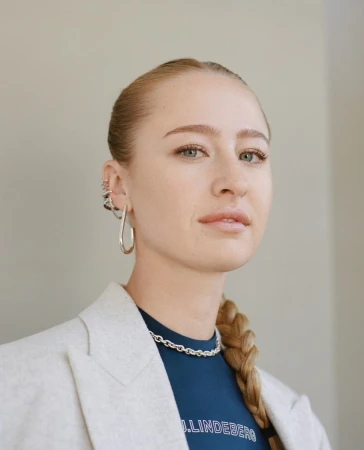 Portrait of a blonde woman wearing a light blazer and silver earrings by Katie Mccurdy
