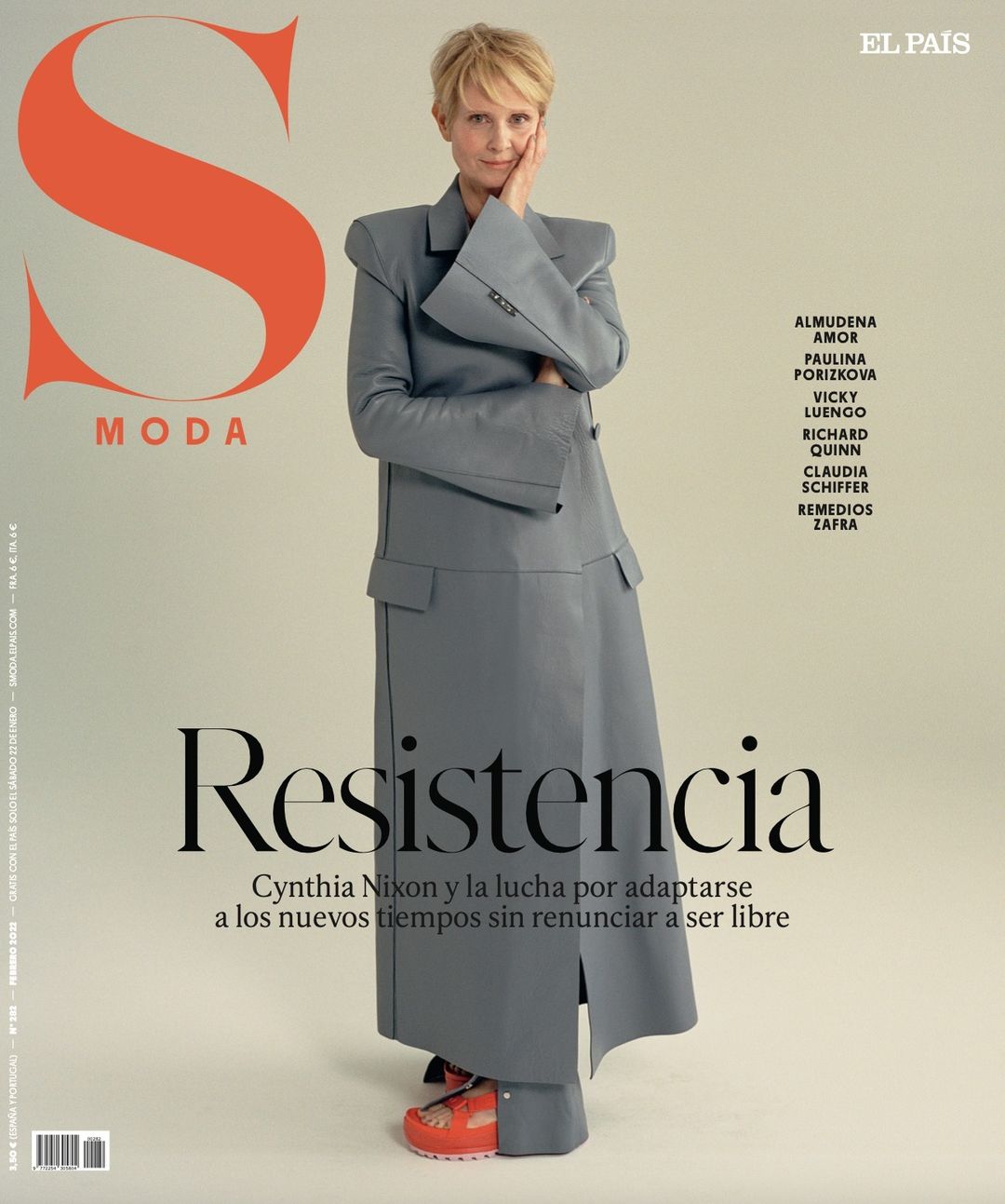 Cynthia Nixon poses on a magazine cover, wearing a grey suit and red platform sandals. The image features the magazine's title and other text.