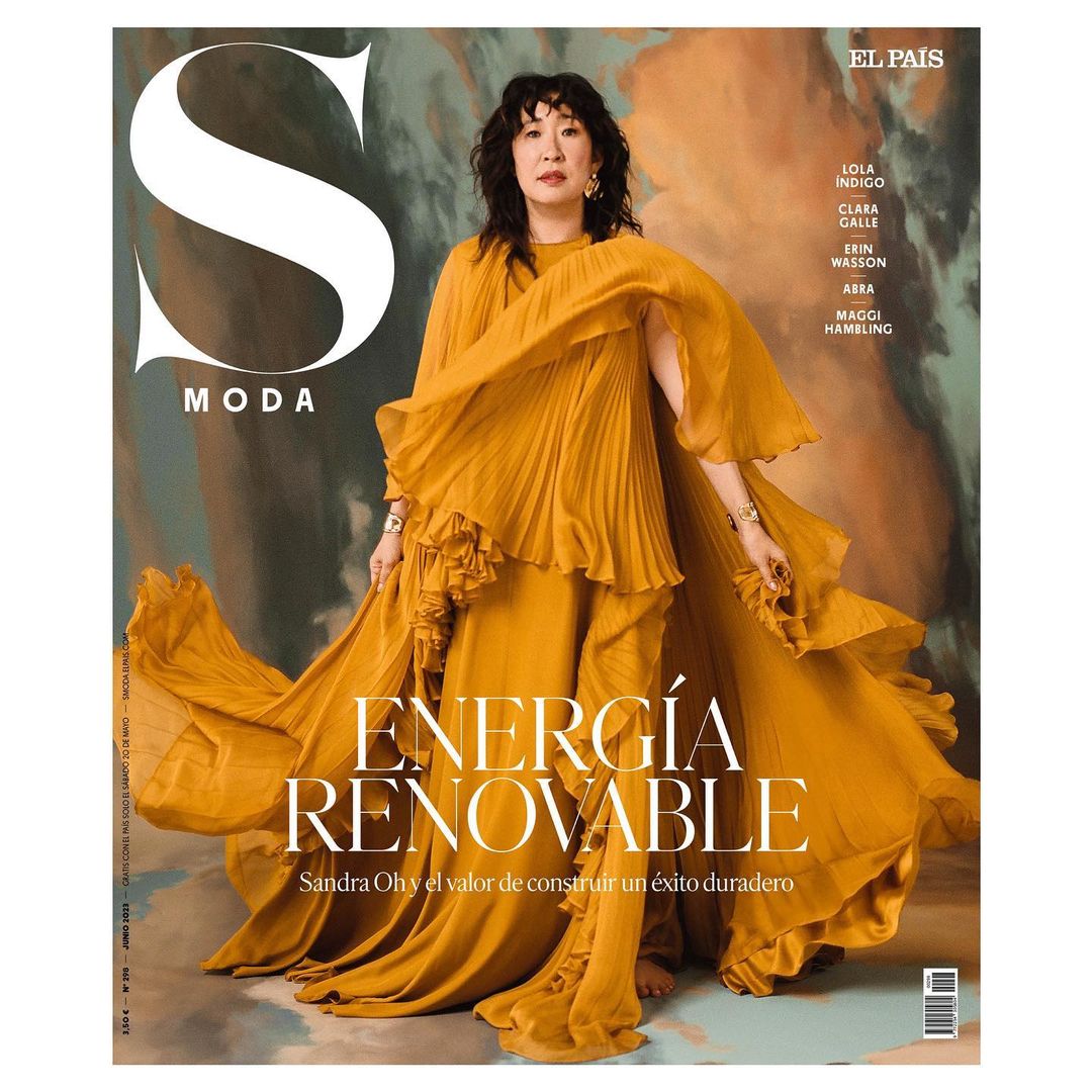 Sandra Oh on magazine cover in flowing yellow dress. 'S Moda' magazine. Text: Energía Renovable. Gold jewelry. Studio lighting. 