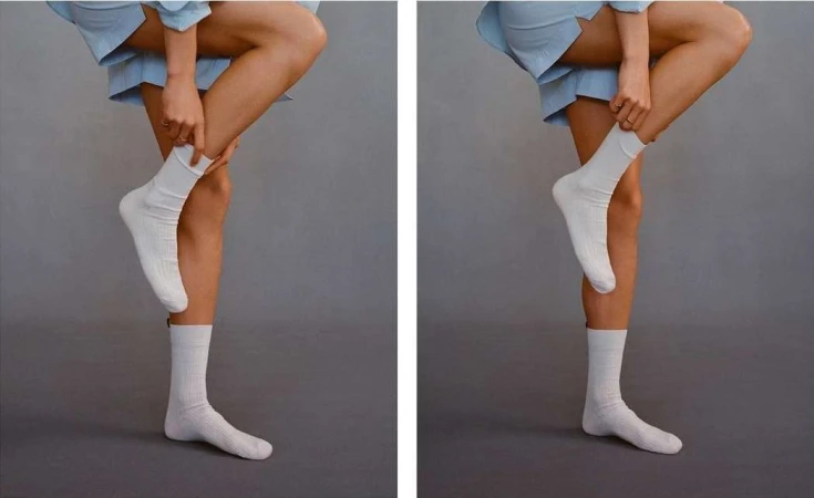 Two side-by-side images of a fair-skinned person wearing a blue outfit pulling up a white sock on their leg against a gray background.