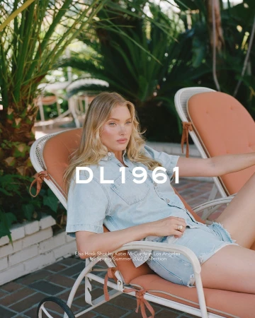 Elsa Hosk lounging on a poolside chair wearing light blue denim shorts and matching short-sleeved denim shirt.