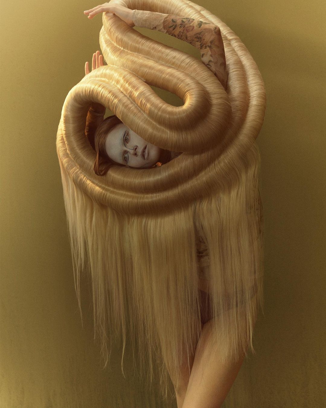 Artistic portrait of a person surrounded by a large arrangement of blonde hair against a muted yellow background, fashion-forward.