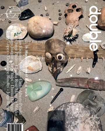 Double magazine cover features various artifacts including carved skulls, rocks and stones, and a jade-like face, displayed on a neutral surface.
