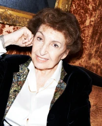 Portrait of an elderly woman wearing a dark velvet jacket and white shirt, photographed by Katja Rahlwes.