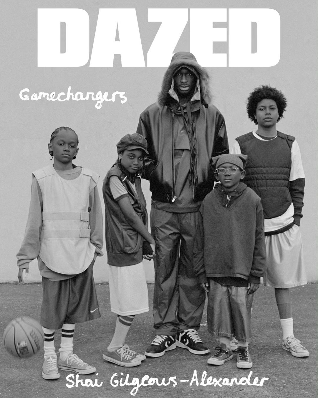 Black and white magazine cover shot of Shai Gilgeous-Alexander and a group of children in athletic apparel standing on a court.
