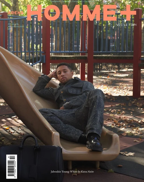 Magazine cover featuring an adult man lounging on a playground slide, with a black leather duffel bag visible in the foreground.
