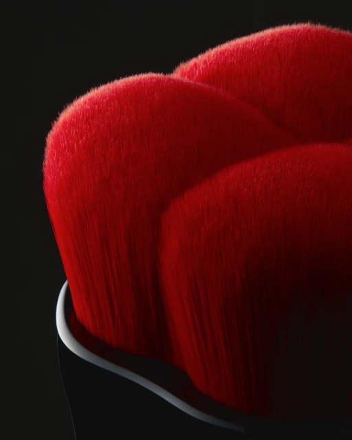 Macro shot of a red makeup brush head with densely packed bristles, set against a dark background, highlighting the texture and color.