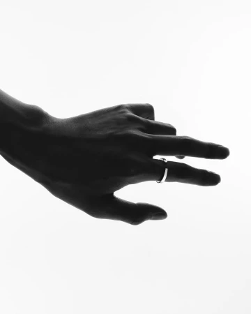 Close-up silhouette of a hand wearing a silver ring against a bright white background by Kazumi Miyamae