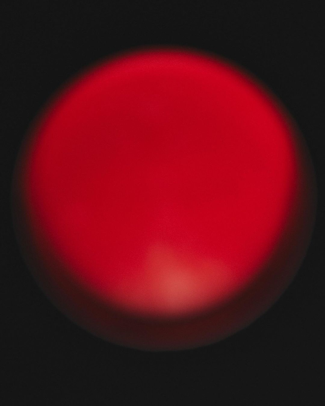 Abstract image of a vibrant red sphere on a dark background, creating a stark contrast and modern aesthetic. Perfect for backgrounds.