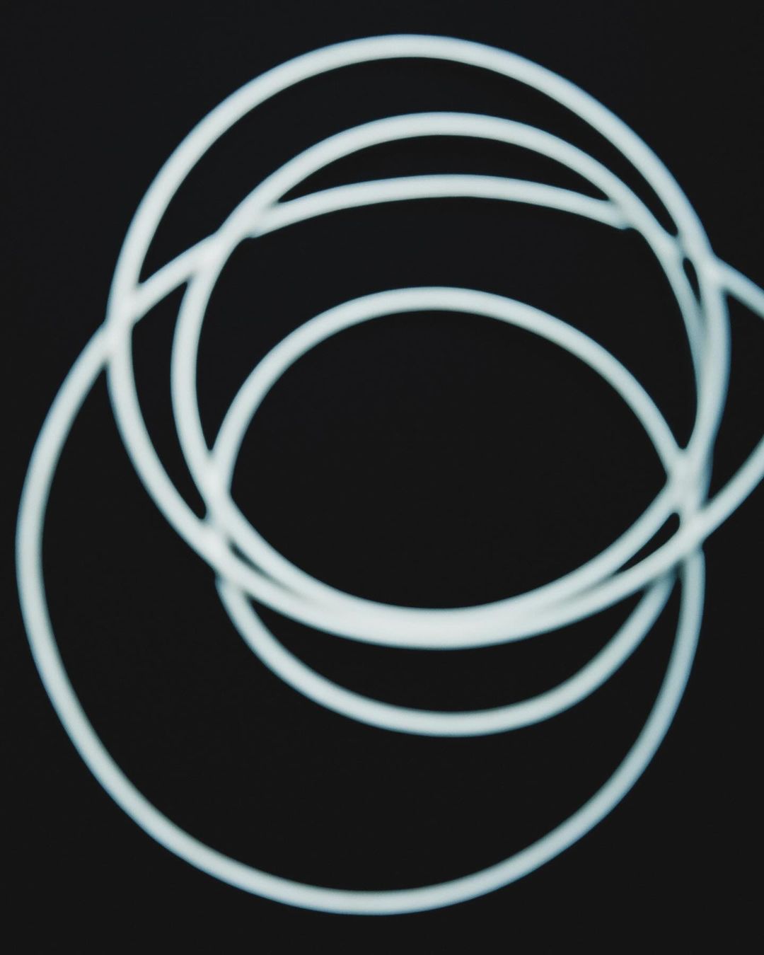 Abstract composition featuring intersecting white circles on a stark black background, creating a minimalist and modern visual.