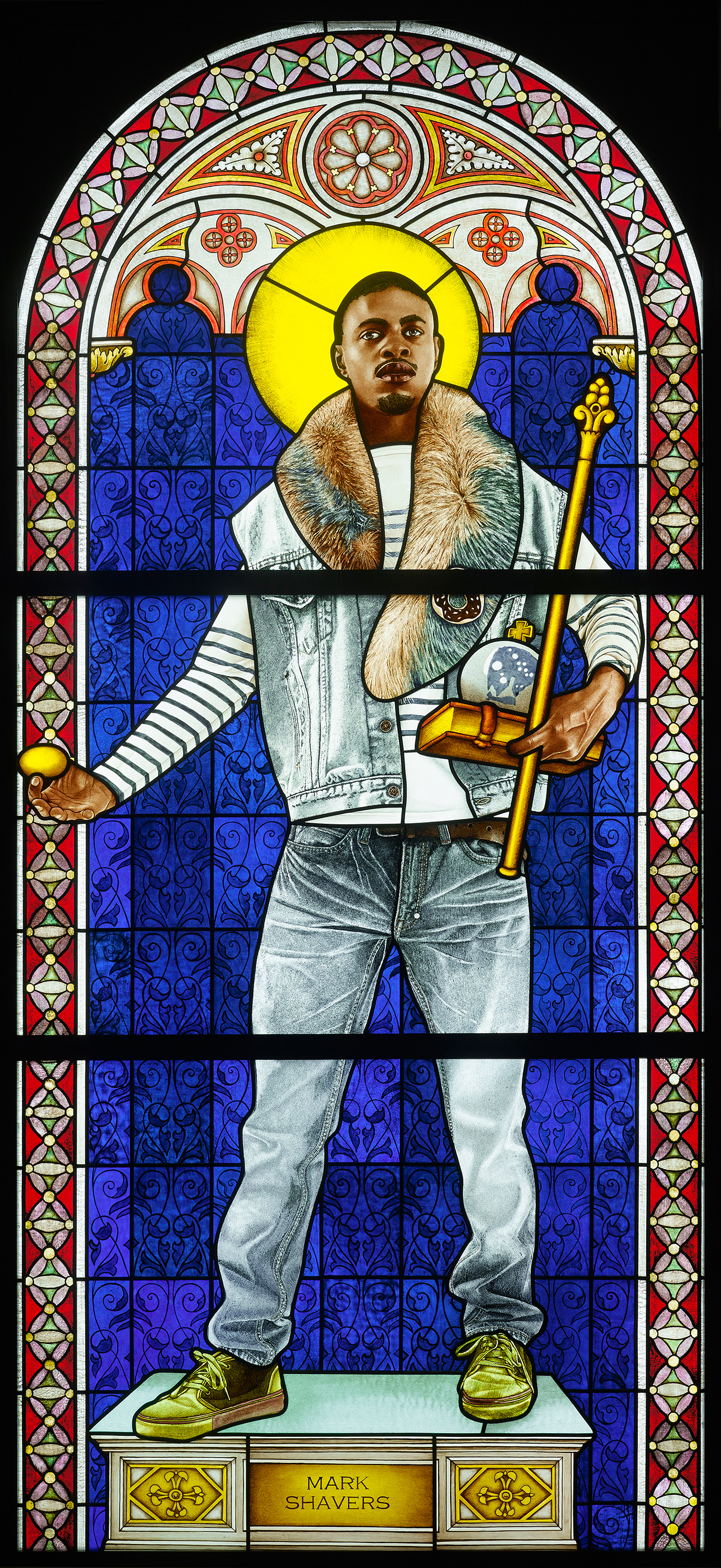 Stained glass art depicting a man in modern casual clothing with a fur collar, holding a staff and orb on a pedestal.
