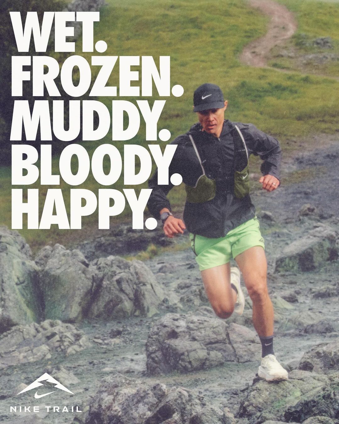 A male runner sprints on a rocky trail wearing sportswear, with a Nike logo and the words 'Wet. Frozen. Muddy. Bloody. Happy.' in the background.