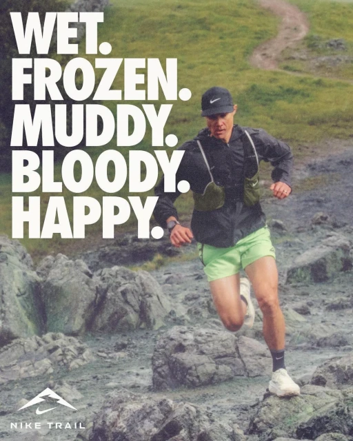 A male runner sprints on a rocky trail wearing sportswear, with a Nike logo and the words 'Wet. Frozen. Muddy. Bloody. Happy.' in the background.