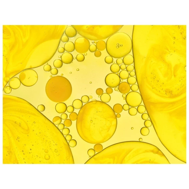 Macro photograph of various sized yellow oil bubbles in water, showcasing texture, color, and patterns.