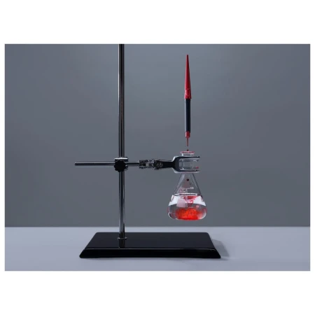 Close-up of a laboratory setup with a flask containing a red liquid being filled by a pipette, showcasing chemistry or science concept.