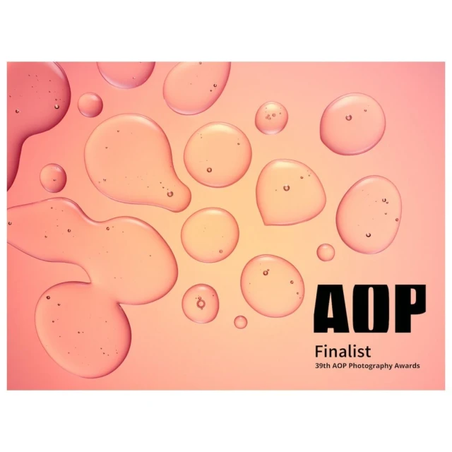 Close-up product shot of water droplets against a gradient peach-colored background, with bold, black AOP Finalist typography.