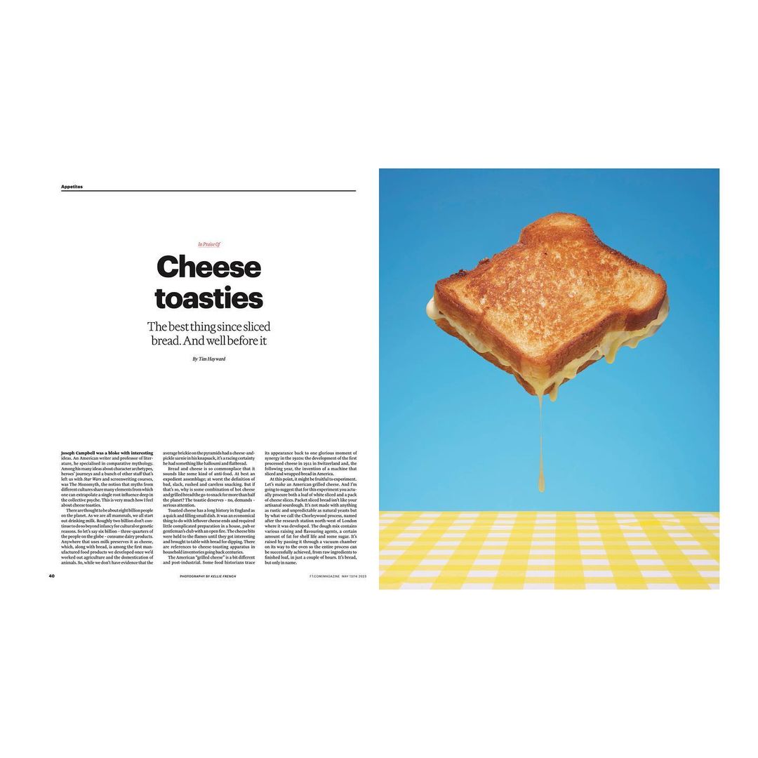 Grilled cheese sandwich levitates against a blue backdrop, casting a shadow on a yellow and white checkered surface below.