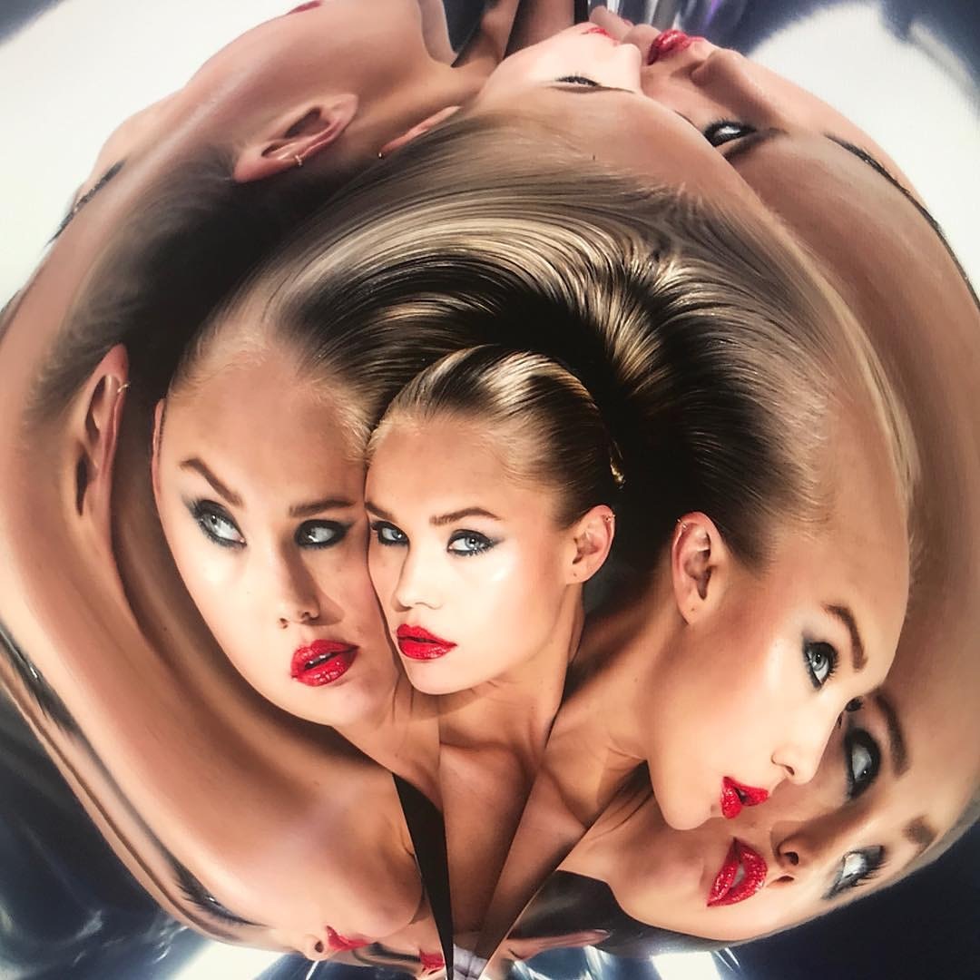 Beauty shot of an adult female with red lipstick and sleek blonde hair, digitally manipulated for a kaleidoscopic effect with a metallic backdrop.