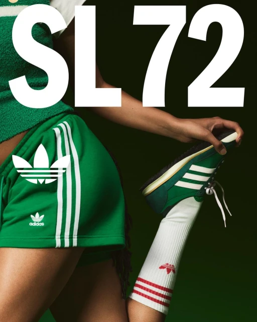 Athletic woman showcases a green and white Adidas SL72 sneaker, paired with matching shorts and striped socks against a dark background.