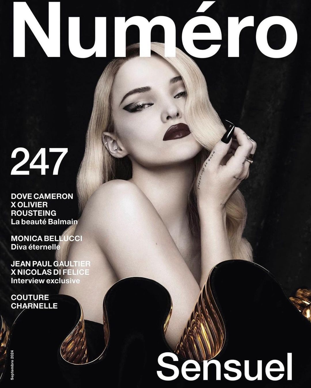 Portrait of Dove Cameron with blonde hair, dark winged eyeliner, and dark lipstick against a dark background, photographed by Kenny Germé