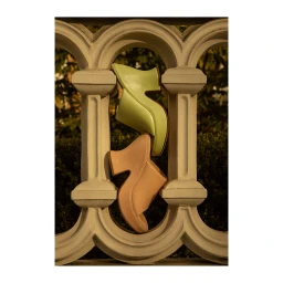 Two platform mule shoes wedged vertically between decorative stone balustrade columns outdoors.