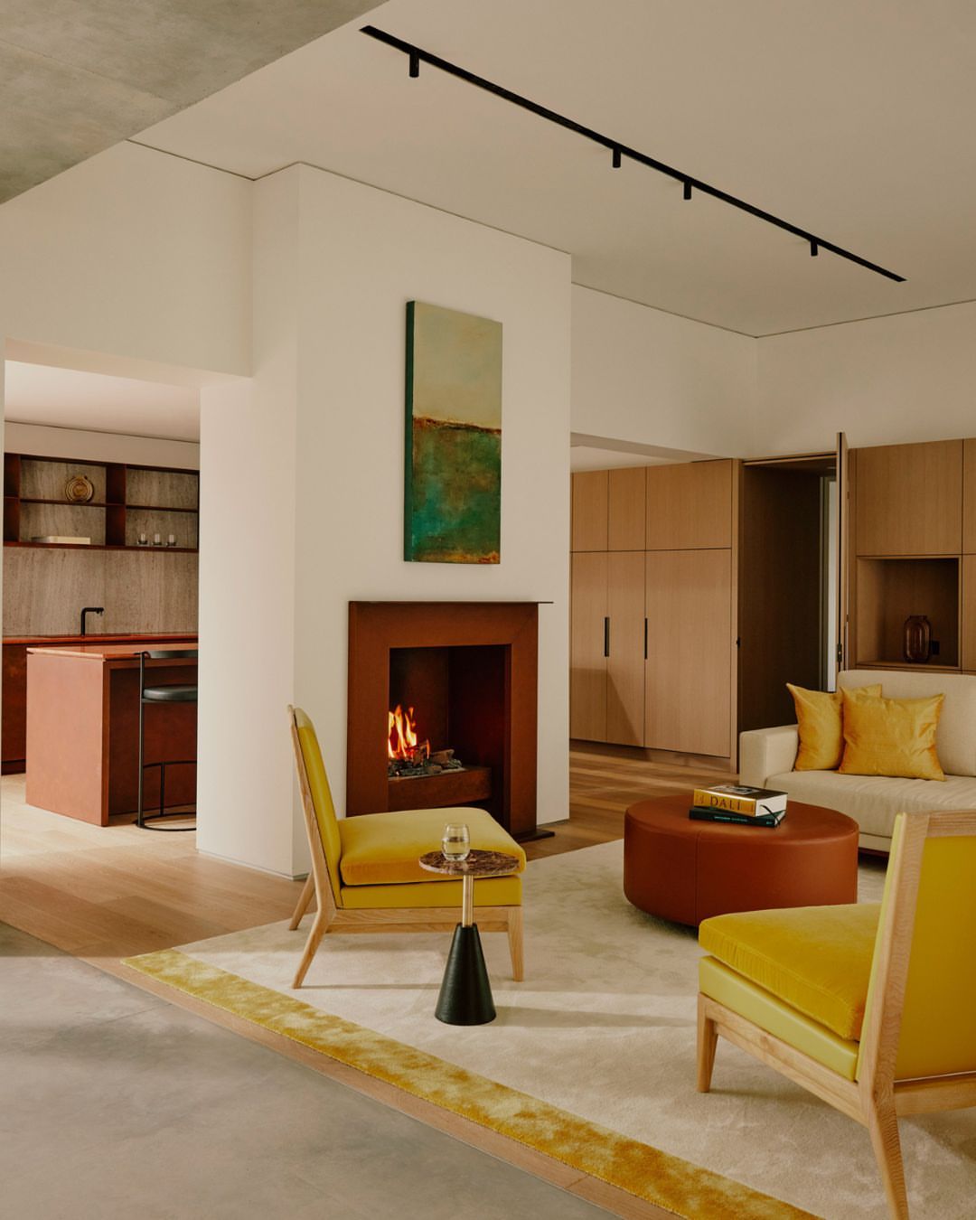 Stylish living room interior with yellow chairs, a brown fireplace, and contemporary art, creating a warm and inviting atmosphere.