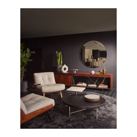 Modern interior living room with two beige armchairs, a round coffee table, wooden credenza, and round wall mirror.
