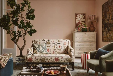 Patterned floral sofa and olive armchair in a cozy living room photographed by Kensington Leverne.