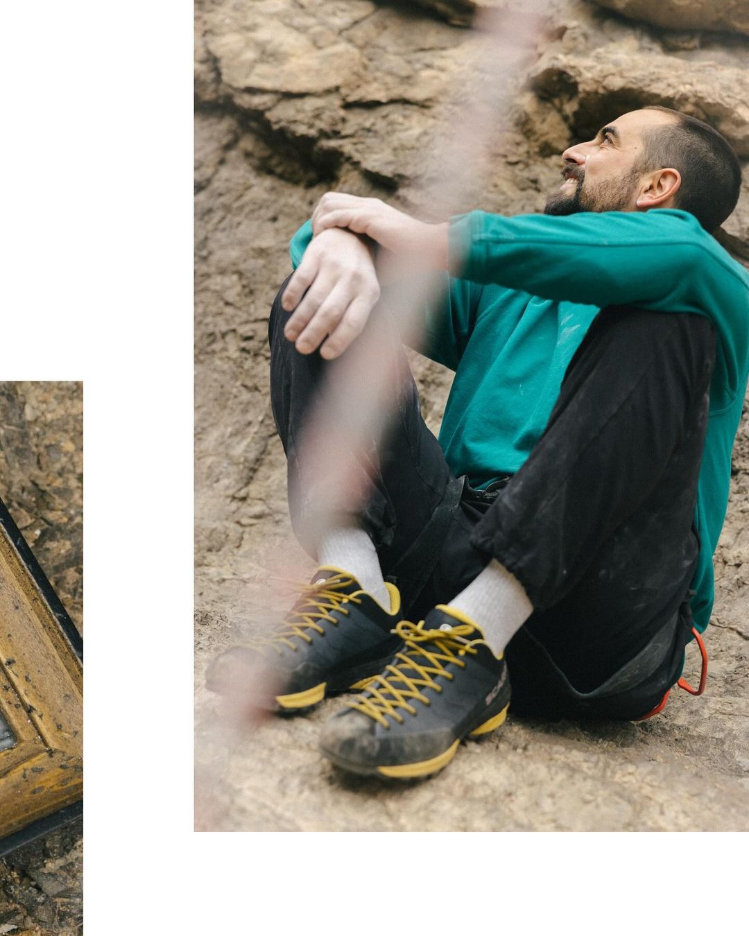 Adult man sits with arms around legs on a rock formation while wearing climbing shoes, black pants and a green sweater.