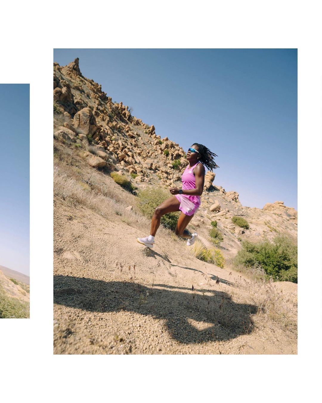 Athletic black woman running downhill on a rocky, arid landscape under a blue sky, wearing athletic gear and sunglasses.