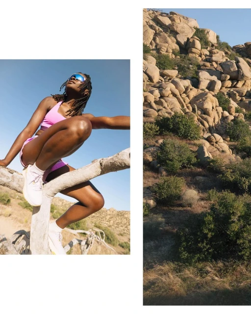 Athletic woman in fitness apparel poses on a tree branch with a mountain landscape backdrop on a sunny day with clear sky.